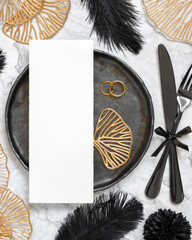 Black and golden wedding table setting with a blank card and rings top view, mockup