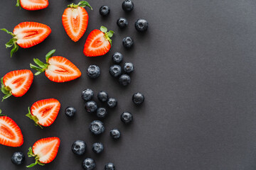 Top view of natural berries on black surface.