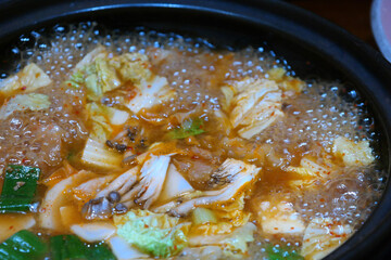 Korean soybean paste stew made with various ingredients such as meat, seafood, vegetables, tofu, and mushrooms by dissolving soybean paste in boiling broth.