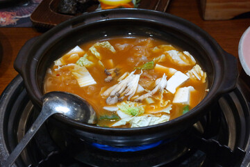Korean soybean paste stew made with various ingredients such as meat, seafood, vegetables, tofu, and mushrooms by dissolving soybean paste in boiling broth.