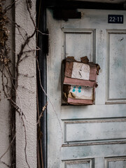 白いドアに掛けられた印象的な赤いポスト