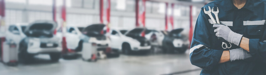 Hands of car mechanic with wrench in garage.Car care maintenance and servicing concept.