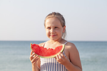 Portrait of a beautiful little girl on the beach in sunlight