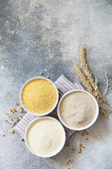 Food and baking gluten free ingredient. Cereals and flours coarse, corn flour, buckwheat flour, chickpeas flour over gray stone background. View from above.