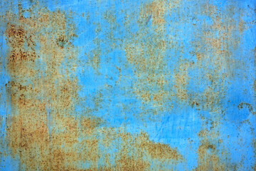 Closeup of a blue metal surface with rust and cracks.