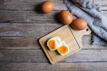 Boiled eggs and raw eggs on a wooden table