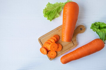 Fresh carrots cut on a wooden chopping board