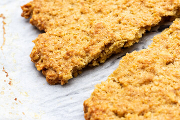 クッキングシートの上の焼きたてオートミールクッキー
