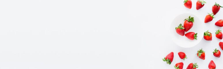 Top view of natural strawberries with leaves on white background, banner.