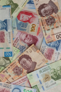 Vertical image of Mexican pesos bills of various denominations on a table with copy space