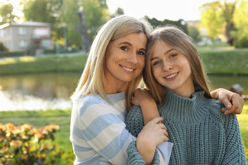 Naklejka premium Happy mother with her daughter spending time together in park on sunny day
