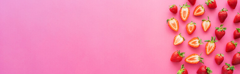 Flat lay with strawberries on pink surface with copy space, banner.