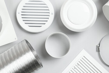 Parts of home ventilation system on light grey background, flat lay