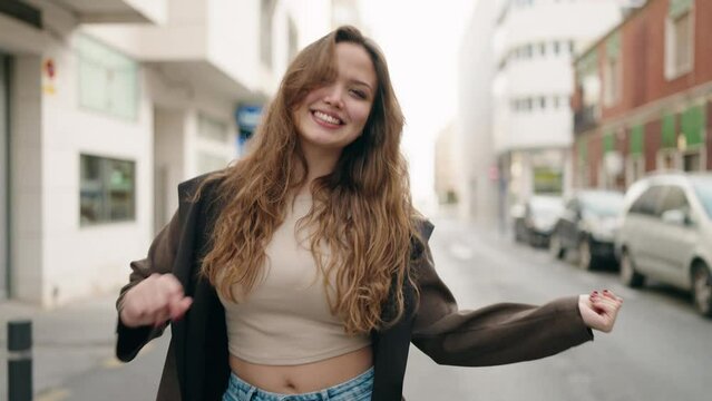 Young hispanic woman smiling confident walking and dancing at street