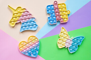 Rainbow pop it fidget toys on color background, flat lay. 