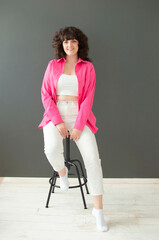 oung happy girl with crooked teeth and cute facial expression with voluminous curly hair poses in...