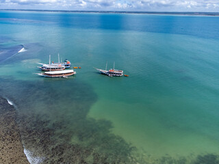 Schooner boat tour on the coral reef in the middle of the sea, Porto Seguro, Bahia, Brazil - natural beauty aerial drone view   