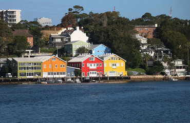 Colourful houses on the shore of the bay, a pier with small boats, Sydney, Australia
