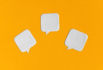 Three white blank stickers on yellow paper background. Back to school, office supplies, stationery mockup minimalistic concept. Empty paper notes template for your logo, message