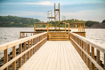 a public three-level diving board at the end of a wooden pier