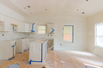 White kitchen interior with painting on wall with finishing works in progress