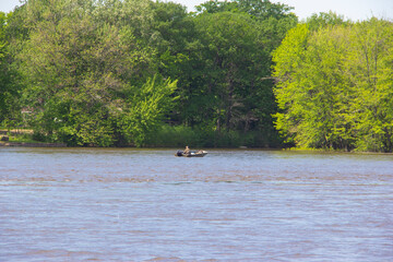 Fototapeta na wymiar Dog with a man fishing off a small boat