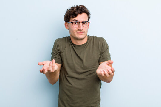young handsome man feeling clueless and confused, not sure which choice or option to pick, wondering