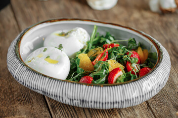 Closeup on bowl of boiled eggs with fresh healthy salad