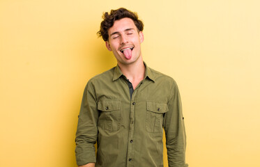 young handsome man with cheerful, carefree, rebellious attitude, joking and sticking tongue out,...