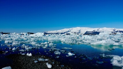 Eisberge und Eisstücke im Sonnenschein am Gletscher in Island.