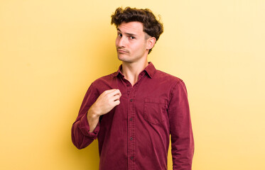 young handsome man looking arrogant, successful, positive and proud, pointing to self