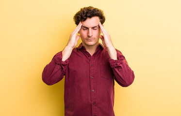 young handsome man looking stressed and frustrated, working under pressure with a headache and...