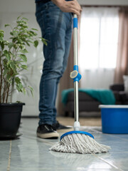 Man mopping floor at home. No face shown