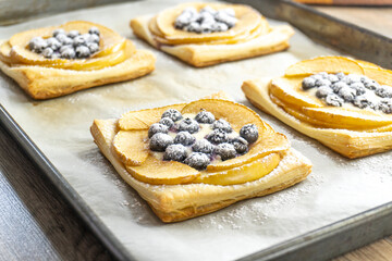 puff pastry with blueberry and apple on a wooden background. food concept