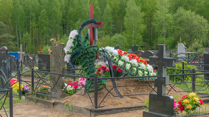 Artificial flowers and funeral wreaths on fresh graves in the city cemetery. City geaveyard.