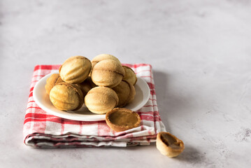 Still life Composition with White Plate Walnuts Sweet Cookies Shaped Nuts on Grey Background Food Concept Copy Space