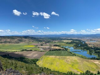 Aerial View of the lush green Rogue Valley in Southern Oregon from atop Table Rock Plateau with fields of green and yellow wildflowers.