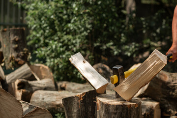 A cleaver ax sticks out in a log. Firewood for kindling the stove. Agriculture,