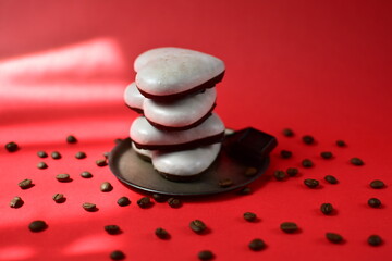 a stock of gingerbread cookies with icing , chocolate and coffee beans on a red background