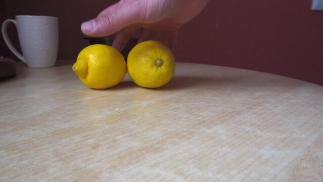 Two yellow lemons on the table. tropical fruit. Preparing a drink. Close-up. dietary product. Vitamin C. Sour taste. Slow motion.