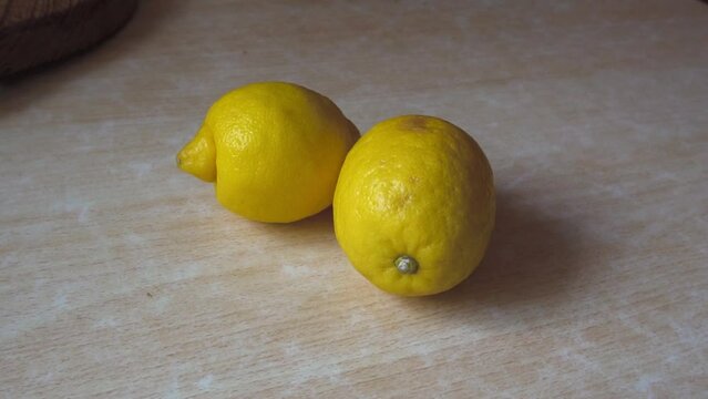 Two yellow lemons on the table. tropical fruit. Preparing a drink. Close-up. dietary product. Vitamin C. Sour taste. Slow motion.