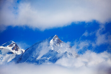 Fototapeta na wymiar Aiguille de Bionnassay peak of Mont Blanc massif in clouds