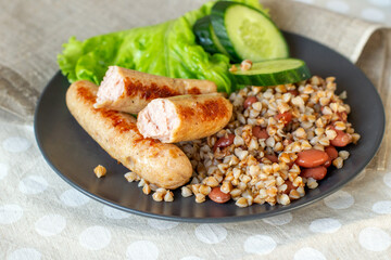 Fried sausages with boiled buckwheat and green vegetables