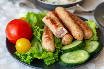 Homemade fried sausages on a bed of green vegetables