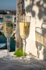 Birthday celebration with two glasses of French champagne sparkling wine and view on colorful fisherman's boats in old harbour in Cassis, Provence, France