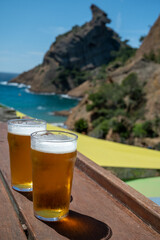Two glasses of fresh cold lager beer served outdoor in snack bar with view on Calanque de Figuerolles in La Ciotat, Provence, France