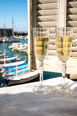 Two glasses of French champagne sparkling wine and view on colorful fisherman's boats in old harbour in Cassis, Provence, France