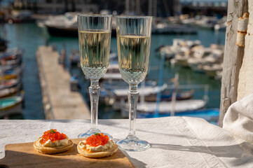 Pairing of blinis with sour cream and salted salmon red caviar and French champagne brut sparkling...