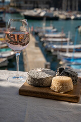 French goat cheeses crottin and selles-sur-cher served with view on boats in harbor of Cassis,...