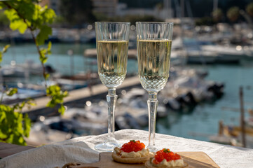 Pairing of blinis with sour cream and salted salmon red caviar and French champagne brut sparkling...